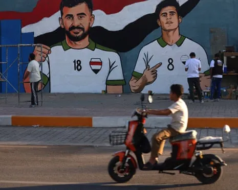 A mural of Iraq's Ibrahim Bayesh alongside forward Aymen Hussein (left) in Sadr City, east of Baghdad