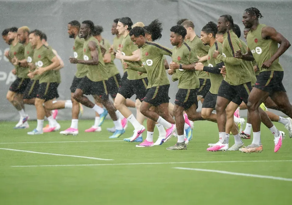 Team Canada players run in the pouring rain during World Cup roster selection camp in Charlotte, N.C., on Tuesday, May 26, 2026. THE CANADIAN PRESS/Nathan Denette