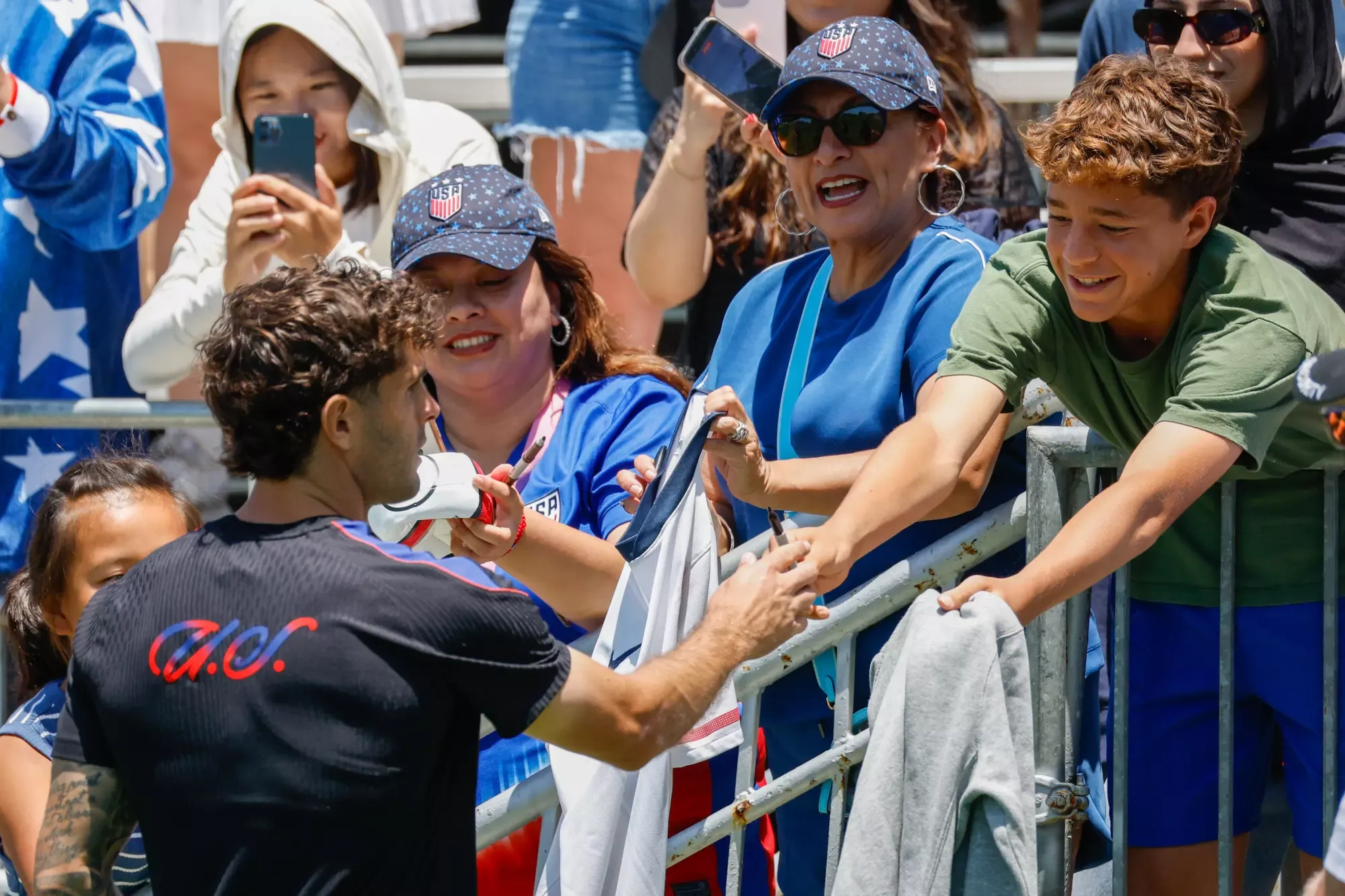 U.S. men's soccer star Christian Pulisic signs autographs for fans during a World Cup training session.