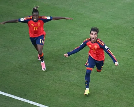 Nico Williams and Ferran Torres of Spain celebrate on a pitch, Williams with arms outstretched