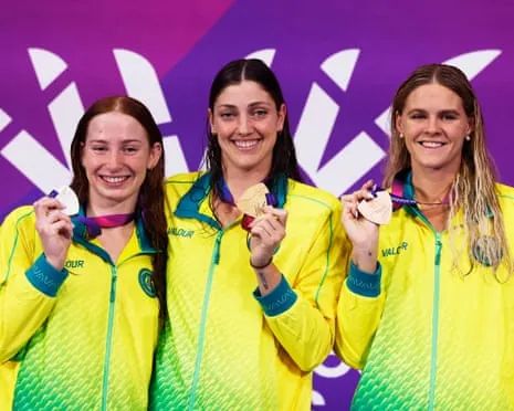 Gold medallist Meg Harris celebrates on the podium after winning the women's 100m freestyle final, with silver medallist Mollie O'Callaghan and bronze medallist Shayna Jack