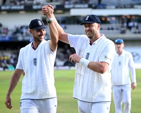 Josh Tongue and Ollie Robinson clasp hands, wth the ball in the latter's other hand, as they walk off having bowled out Pakistan