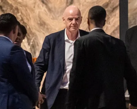 Fifa president Gianni Infantino walks through a lobby surrounded by security personnel