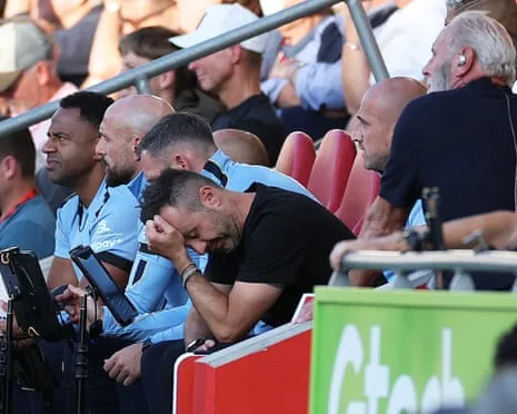 The Tottenham manager Roberto De Zerbi holds his head in his hands during his team's Premier League defeat by Brentford at the Gtech Stadium.