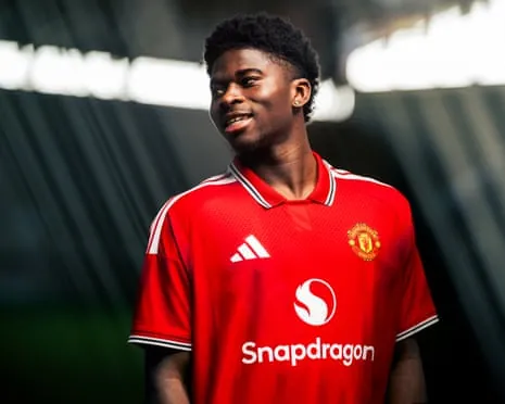 Carlos Baleba poses in a Manchester United shirt