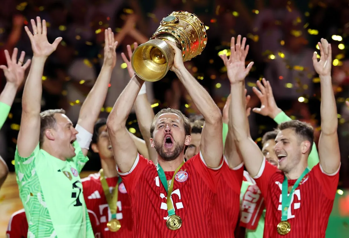 BERLIN, GERMANY - MAY 23: Harry Kane of FC Bayern Munich lifts the DFB Cup Trophy as the team celebrates following victory during the DFB Cup Final 2026 match between FC Bayern München and VfB Stuttgart at Olympiastadion on May 23, 2026 in Berlin, Germany. (Photo by Alex Grimm/Getty Images)